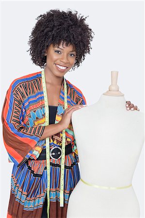 seamstress - Portrait of African American female fashion designer with tailor's dummy over gray background Stock Photo - Premium Royalty-Free, Code: 693-06379249