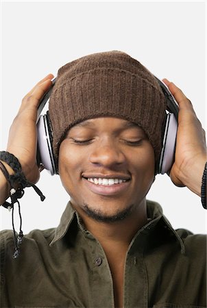 Close-up of relaxed young man listening music through headphones Stock Photo - Premium Royalty-Free, Code: 693-06379485