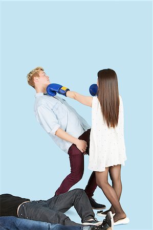 Female boxer punching man with people lying in foreground Stock Photo - Premium Royalty-Free, Code: 693-06379602