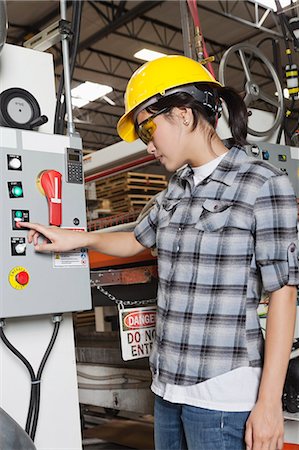 simsearch:693-06379747,k - Female industrial worker operating manufacturing machine at factory Stock Photo - Premium Royalty-Free, Code: 693-06379664
