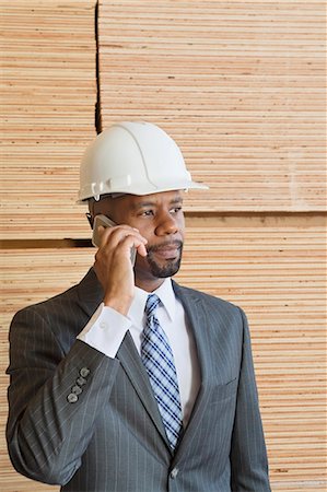simsearch:693-06379747,k - African American male engineer on phone call with stacked wooden planks in background Stock Photo - Premium Royalty-Free, Code: 693-06379698