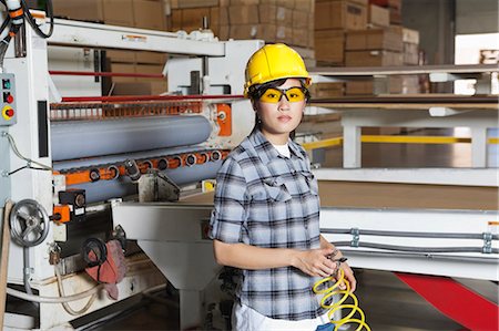 simsearch:693-06379747,k - Portrait of an Asian female industrial worker with holding wire with machinery in background Stock Photo - Premium Royalty-Free, Code: 693-06379755