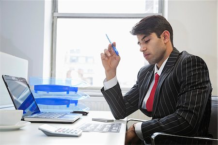 An Indian businessman working at office desk Stock Photo - Premium Royalty-Free, Code: 693-06379803