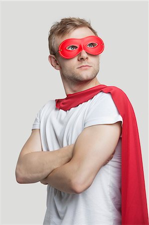 simsearch:693-06435933,k - Young man in red superhero costume looking up over gray background Stock Photo - Premium Royalty-Free, Code: 693-06380065