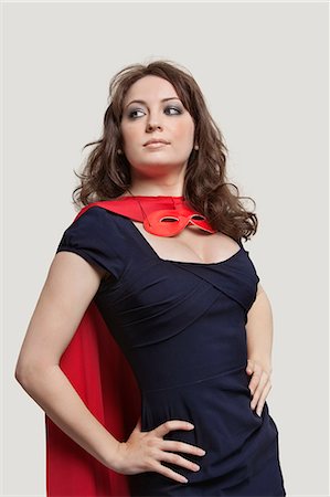 Beautiful woman in superhero costume over gray background Stock Photo - Premium Royalty-Free, Code: 693-06380089