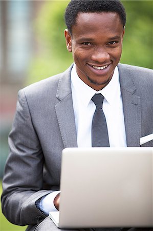 Close-up portrait of African American Businessman working on a laptop outdoors Stock Photo - Premium Royalty-Free, Code: 693-06403151