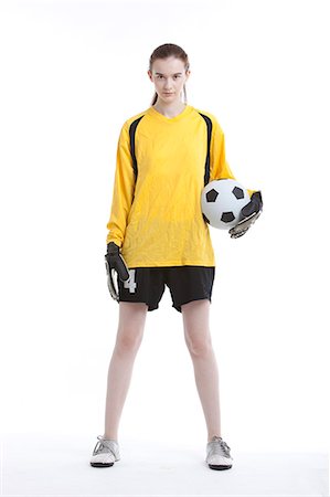 Portrait of young woman with soccer ball against white background Stock Photo - Premium Royalty-Free, Code: 693-06403244