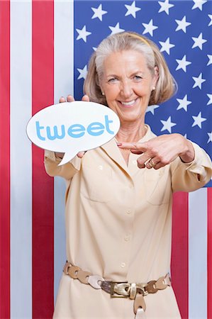 Portrait of senior woman with tweet bubble against American flag Stock Photo - Premium Royalty-Free, Code: 693-06403443
