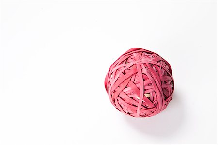 Close-up of rubber band ball over white background Stock Photo - Premium Royalty-Free, Code: 693-06435807