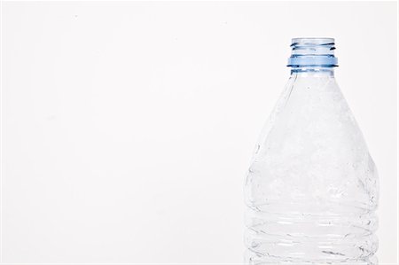 Close-up view of empty plastic bottle over white background Stock Photo - Premium Royalty-Free, Code: 693-06435801