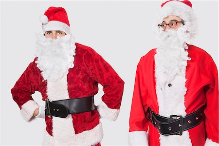 simsearch:693-06435898,k - Young men in Santa costume standing against gray background Stock Photo - Premium Royalty-Free, Code: 693-06435896