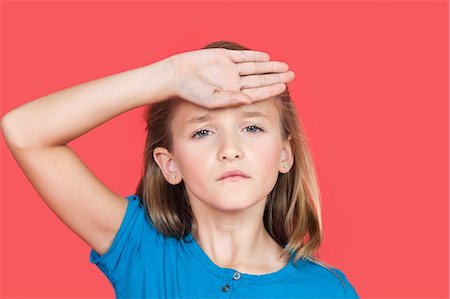 Portrait of young girl checking self temperature against red background Stock Photo - Premium Royalty-Free, Code: 693-06436041