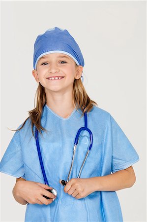 doctor child - Portrait of young girl in surgeon's costume against gray background Stock Photo - Premium Royalty-Free, Code: 693-06436058