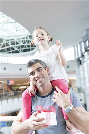 shopping mall - Young daughter sits on fathers shoulders Stock Photo - Premium Royalty-Free, Code: 693-06967374