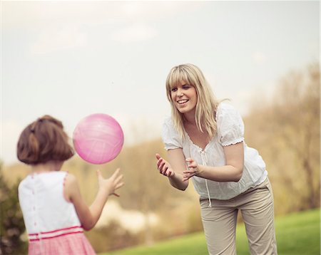 positive - Mother throwing ball to daughter in park Photographie de stock - Premium Libres de Droits, Code: 693-06967428