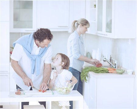 dinner table family - Father and Daughter looking at each other whilst preparing healthy meal in kitchen Foto de stock - Sin royalties Premium, Código: 693-06967473