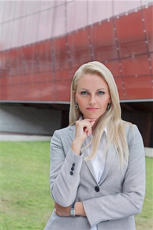 Portrait of confident businesswoman standing with hand on chin against office building Stock Photo - Premium Royalty-Free, Code: 693-07444440