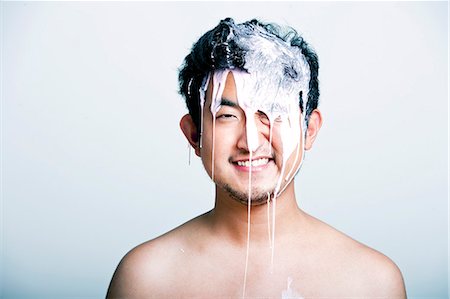 simsearch:622-06809285,k - Shirtless young man with pink paint falling on his head against gray background Stock Photo - Premium Royalty-Free, Code: 693-07444543