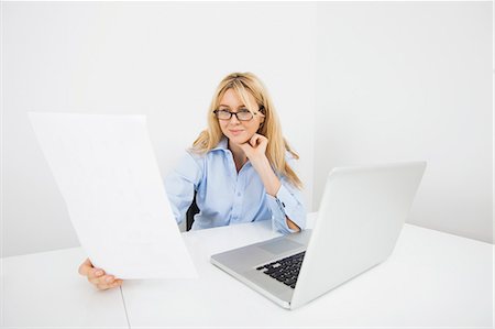 Businesswoman reading document in office Stock Photo - Premium Royalty-Free, Code: 693-07455983