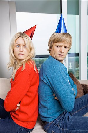 Side view of annoyed couple in Christmas sweaters and party hats sitting back to back at home Foto de stock - Sin royalties Premium, Código: 693-07456040