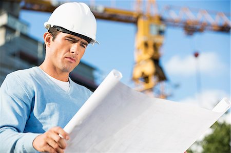 Male architect reviewing blueprint at construction site Stock Photo - Premium Royalty-Free, Code: 693-07456142