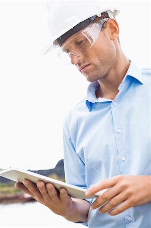 Male architect looking at tablet PC against sky Stock Photo - Premium Royalty-Free, Code: 693-07456154