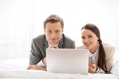 Portrait of happy business couple with laptop in hotel Stock Photo - Premium Royalty-Free, Code: 693-07456252