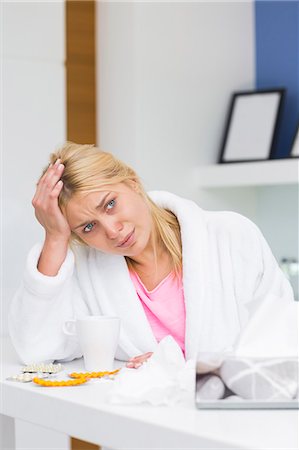 simsearch:693-07456416,k - Young woman suffering from headache in kitchen Foto de stock - Sin royalties Premium, Código: 693-07456345