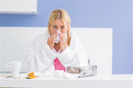 simsearch:693-07456416,k - Portrait of young woman blowing nose in tissue paper Foto de stock - Sin royalties Premium, Código: 693-07456346