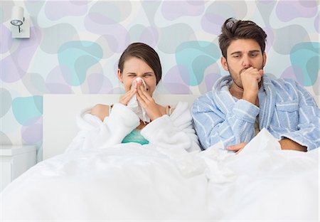 Young couple suffering from cold and flu in bed at home Stock Photo - Premium Royalty-Free, Code: 693-07456388