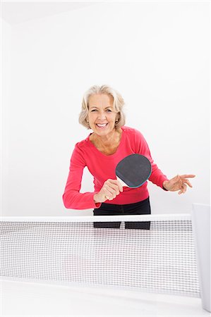 Portrait of happy senior woman playing table tennis Stock Photo - Premium Royalty-Free, Code: 693-07456473