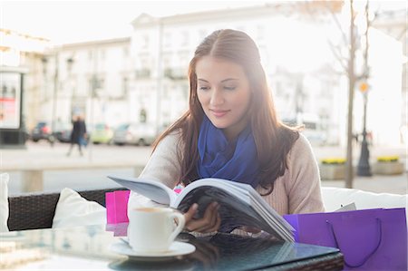 Beautiful woman reading book at sidewalk cafe Stock Photo - Premium Royalty-Free, Code: 693-07542314