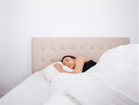 Beautiful young woman sleeping in bed Photographie de stock - Premium Libres de Droits, Code: 693-07542354