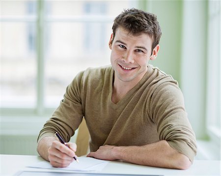 portrait businessman one person - Portrait of handsome businessman writing on document at desk in office Stock Photo - Premium Royalty-Free, Code: 693-07672557