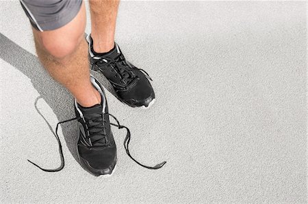 simsearch:693-07672615,k - Low section of sporty man with untied shoelace standing on street Stock Photo - Premium Royalty-Free, Code: 693-07672608