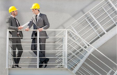 Full length of young male architect discussing on stairway Stock Photo - Premium Royalty-Free, Code: 693-07672640