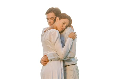 simsearch:693-07672684,k - Affectionate young couple with eyes closed hugging in park against clear sky Stock Photo - Premium Royalty-Free, Code: 693-07672763