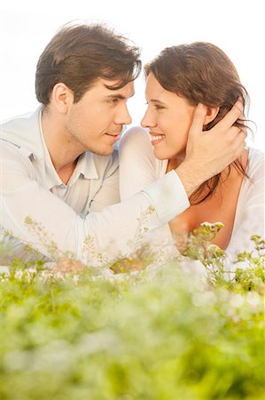 simsearch:693-07672684,k - Affectionate man touching woman while looking at her on grass Stock Photo - Premium Royalty-Free, Code: 693-07672771