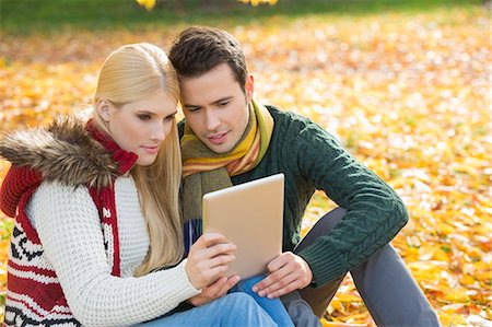 simsearch:693-07542313,k - Couple using digital tablet together in park during autumn Stock Photo - Premium Royalty-Free, Code: 693-07672901