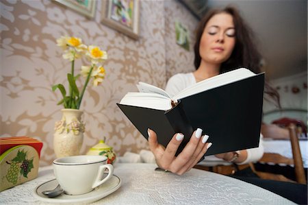 simsearch:693-07672977,k - Young woman reading book in cafe Photographie de stock - Premium Libres de Droits, Code: 693-07672973