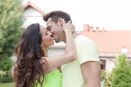 Side view of romantic young couple kissing outdoors Foto de stock - Sin royalties Premium, Código: 693-07673047