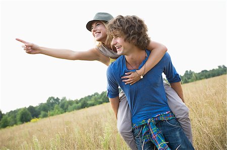 scenic view point sign - Woman showing something while enjoying piggyback ride on man in field Stock Photo - Premium Royalty-Free, Code: 693-07673179