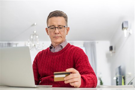 simsearch:400-05354672,k - Mature man using credit card and laptop to shop online at home Stock Photo - Premium Royalty-Free, Code: 693-07673226