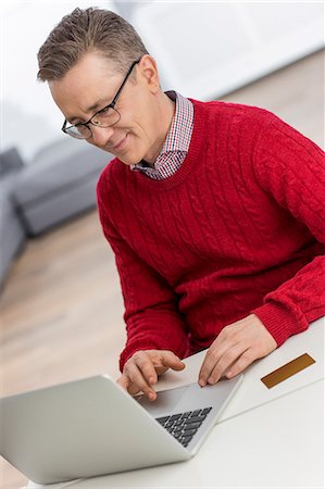 simsearch:400-05354672,k - Mature man using laptop at table in house Stock Photo - Premium Royalty-Free, Code: 693-07673234