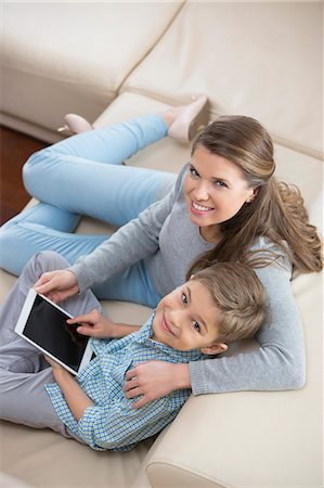 simsearch:693-07542313,k - High angle portrait of mother and son with tablet PC sitting on sofa Stock Photo - Premium Royalty-Free, Code: 693-07673255