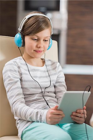 simsearch:693-07542313,k - Cute girl listening music while using digital tablet at home Stock Photo - Premium Royalty-Free, Code: 693-07673274