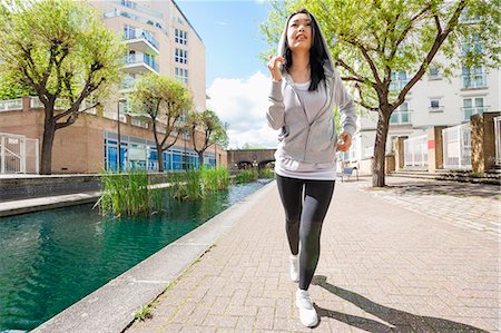 simsearch:693-07672615,k - Full length of fit young woman running by canal against buildings Stock Photo - Premium Royalty-Free, Code: 693-07912088