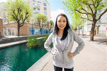 simsearch:693-07672615,k - Portrait of beautiful fit woman standing by canal against buildings Stock Photo - Premium Royalty-Free, Code: 693-07912089