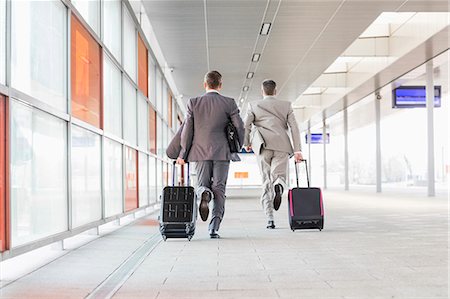 simsearch:695-05773315,k - Full length rear view of businessmen with luggage running on railroad platform Stock Photo - Premium Royalty-Free, Code: 693-07912308