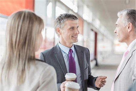 Businessman communicating with colleagues on railroad platform Stock Photo - Premium Royalty-Free, Code: 693-07912321